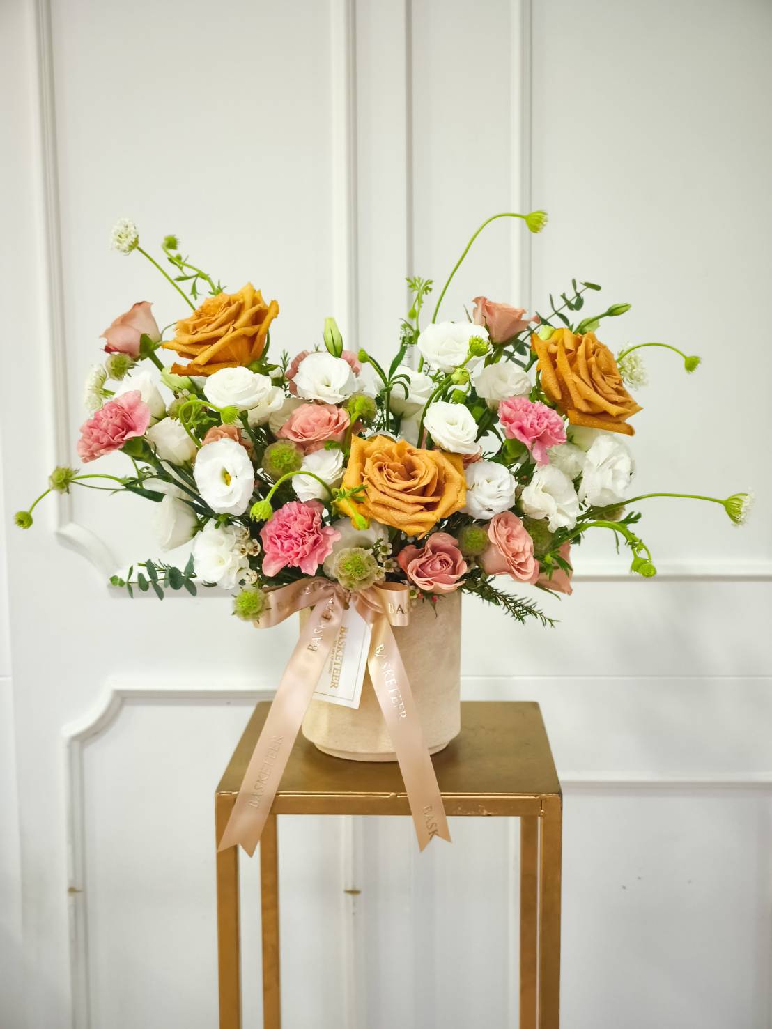 Luxury flower box with caramel roses, pink roses, white lisianthus, pink carnations, and greenery accents with satin ribbon.
