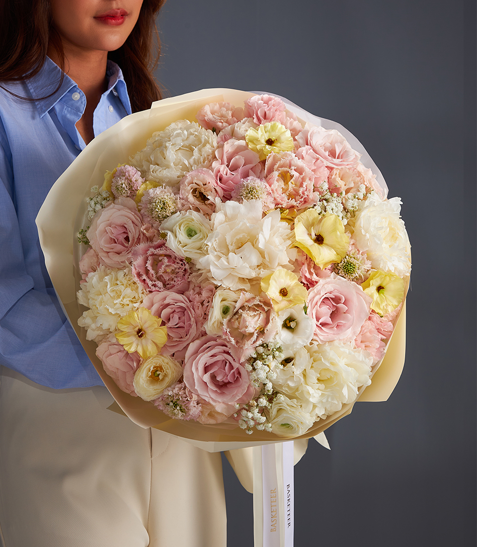 Luxury pastel bouquet with roses lisianthus and ranunculus in pink cream and yellow shades for premium flower delivery in Bangkok