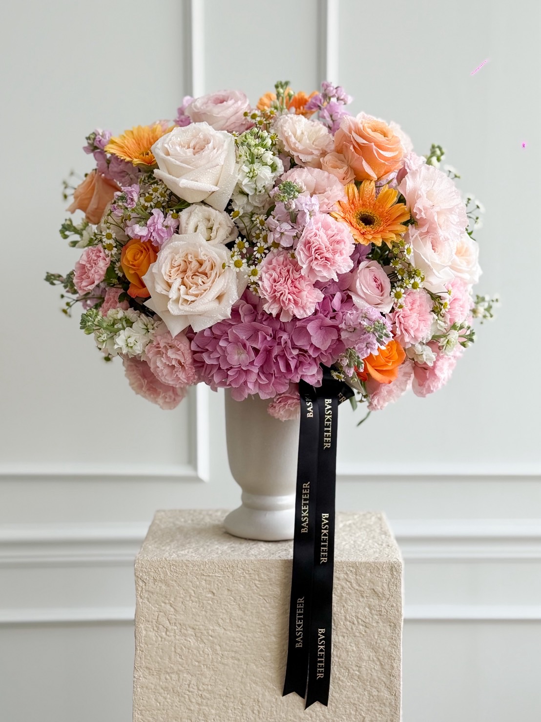 Luxury vase arrangement with roses, hydrangeas, carnations, gerberas, chamomile, and stock flowers in pastel and bright tones.