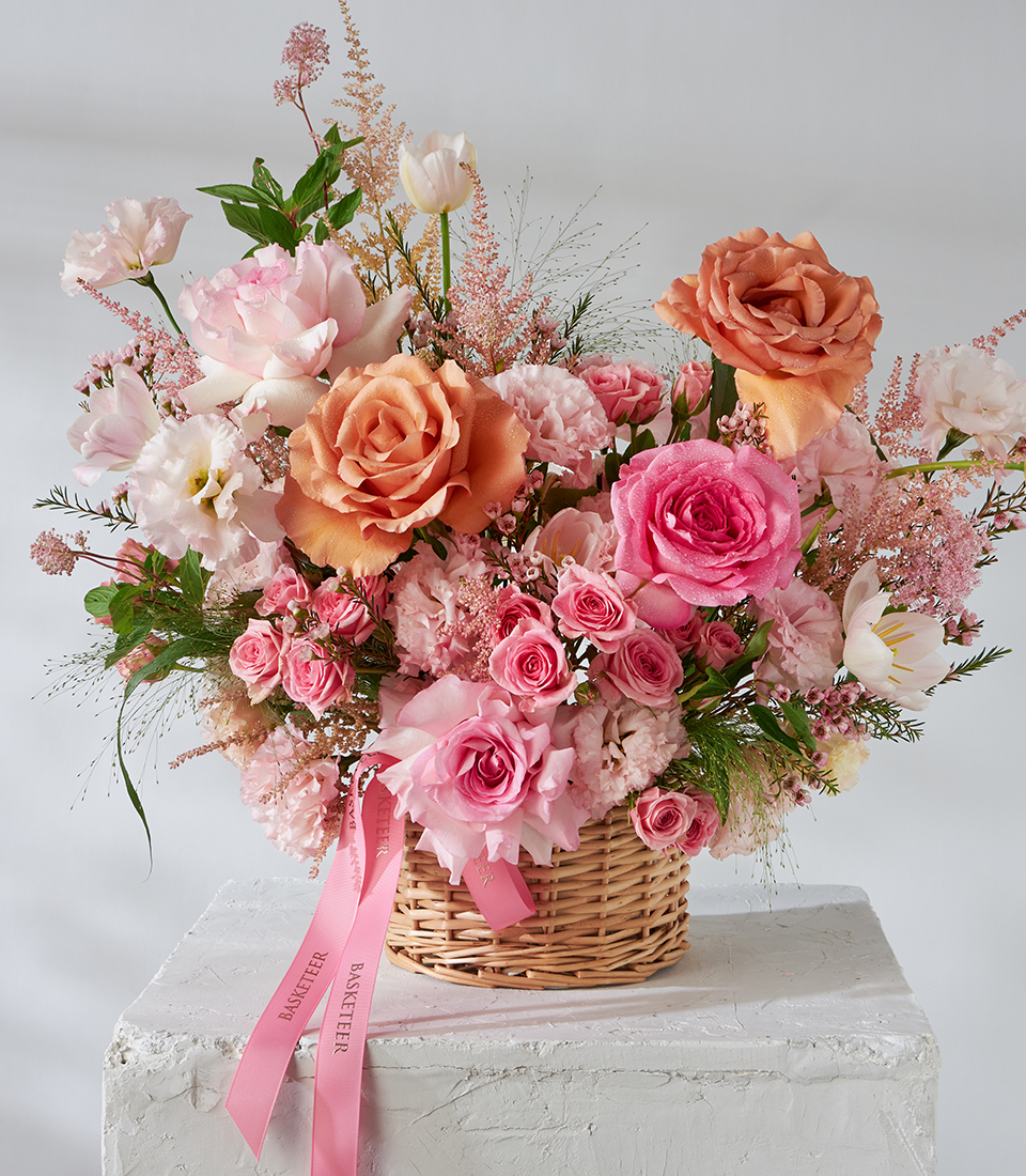 Front view basket with peach roses, pink roses and tulips.