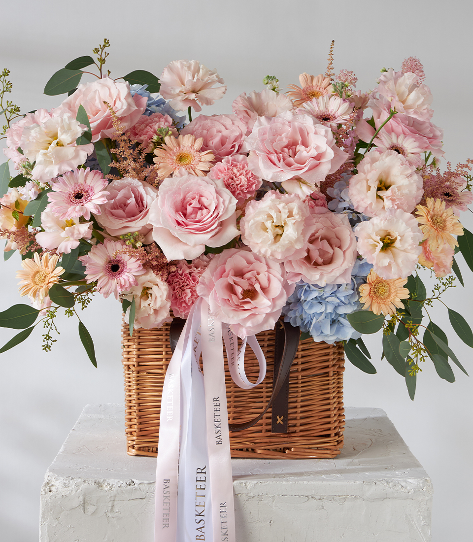Front view of pink rose, carnation and gerbera basket bouquet.