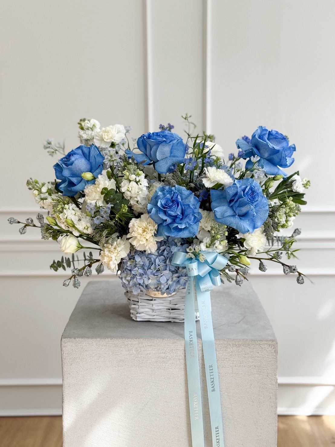 Blue and white flower basket with roses, hydrangeas, and carnations from Flowers by Basketeer — luxury flower delivery in Bangkok.
