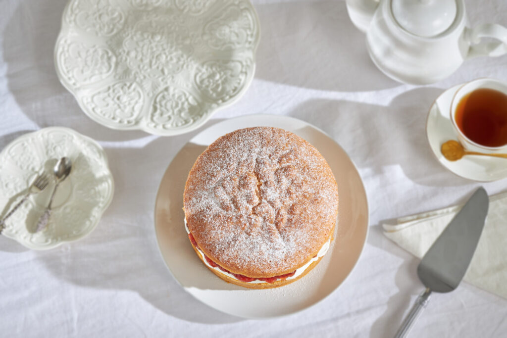 Classic Victoria sponge cake with cream and jam served with tea at Charlotte Bakery Bangkok