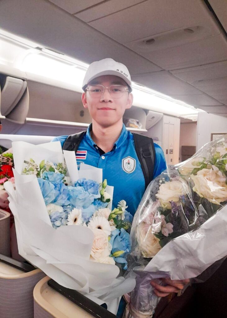 Man holding blue and white bouquet from Flowers by Basketeer on an airplane