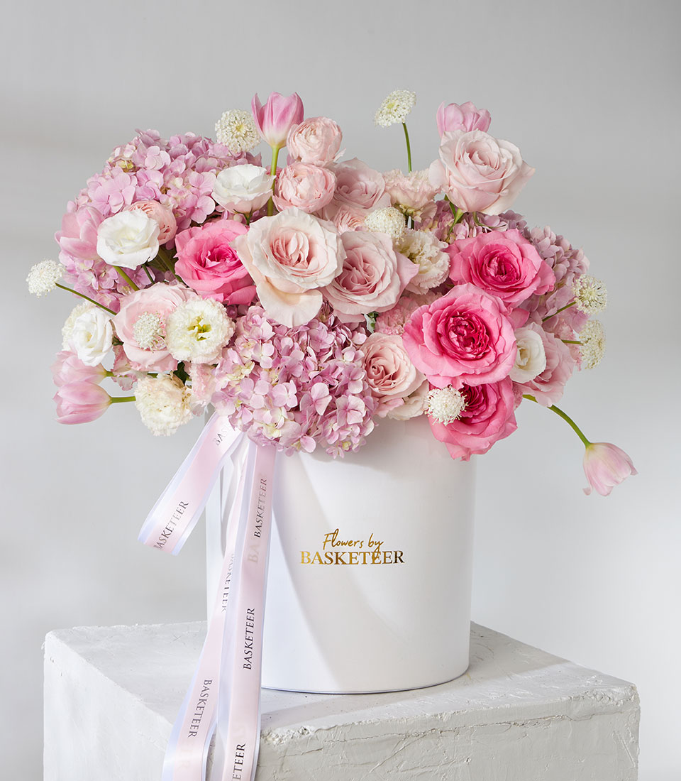 Blush and fuchsia roses in elegant round box
