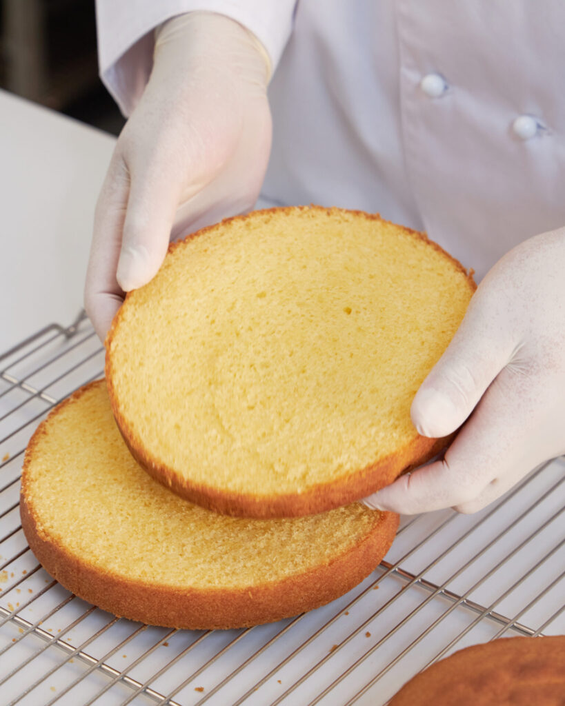 Baker preparing sponge cake layers for Victoria sponge at Charlotte Bakery Bangkok