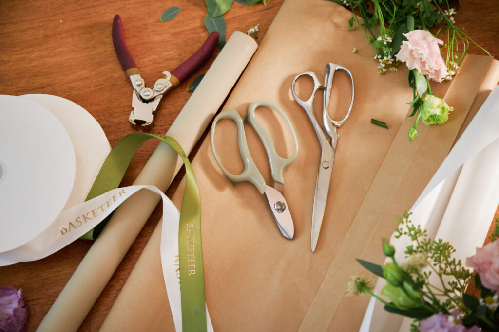 Florist tools and Basketeer ribbons arranged on a wooden worktable