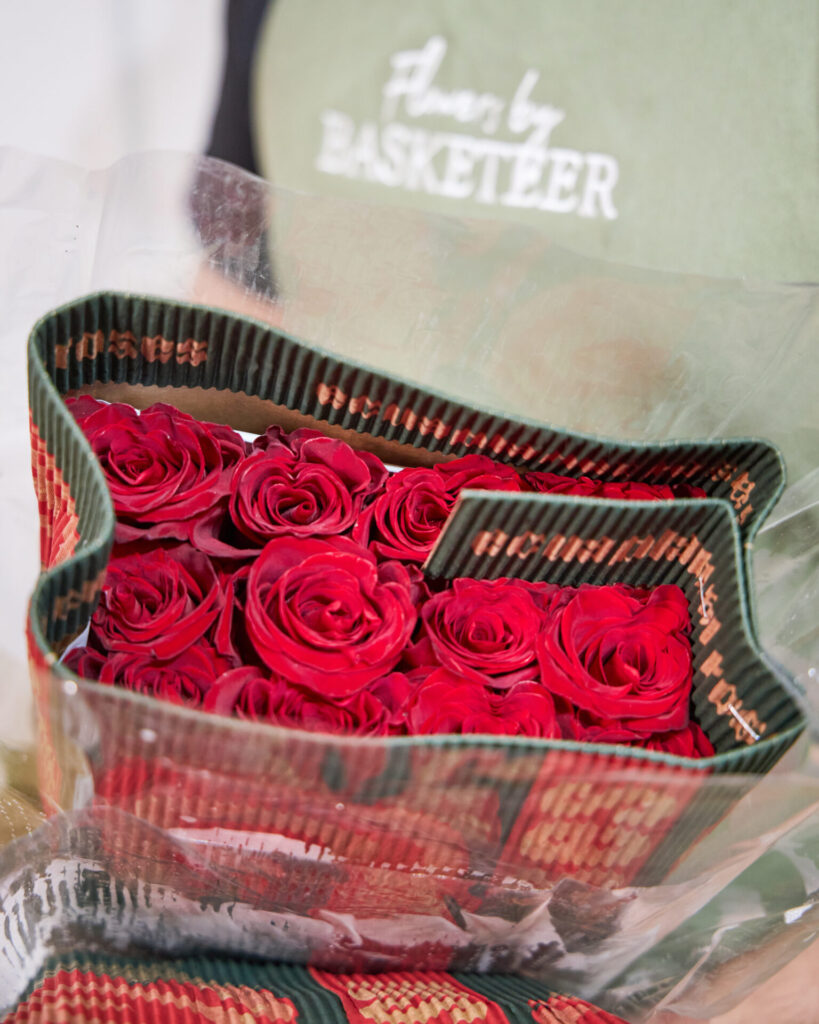 Florist from Flowers by Basketeer holding a package of fresh red roses