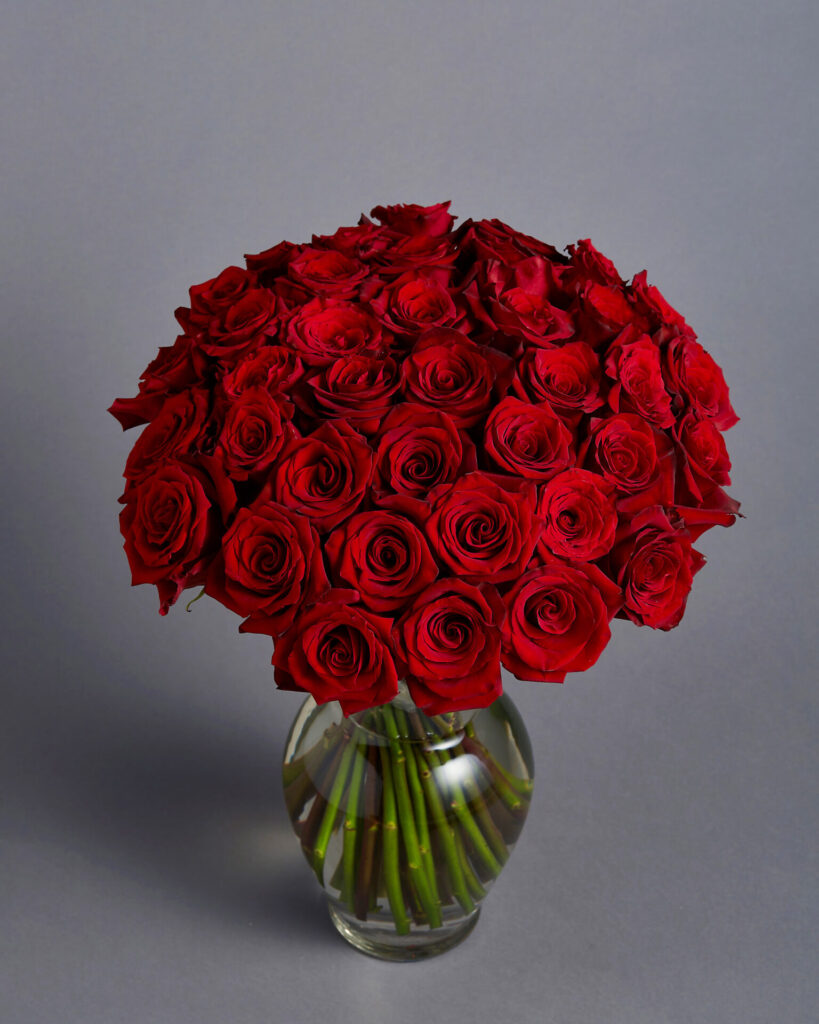 Elegant arrangement of red roses in a glass vase from Flowers by Basketeer