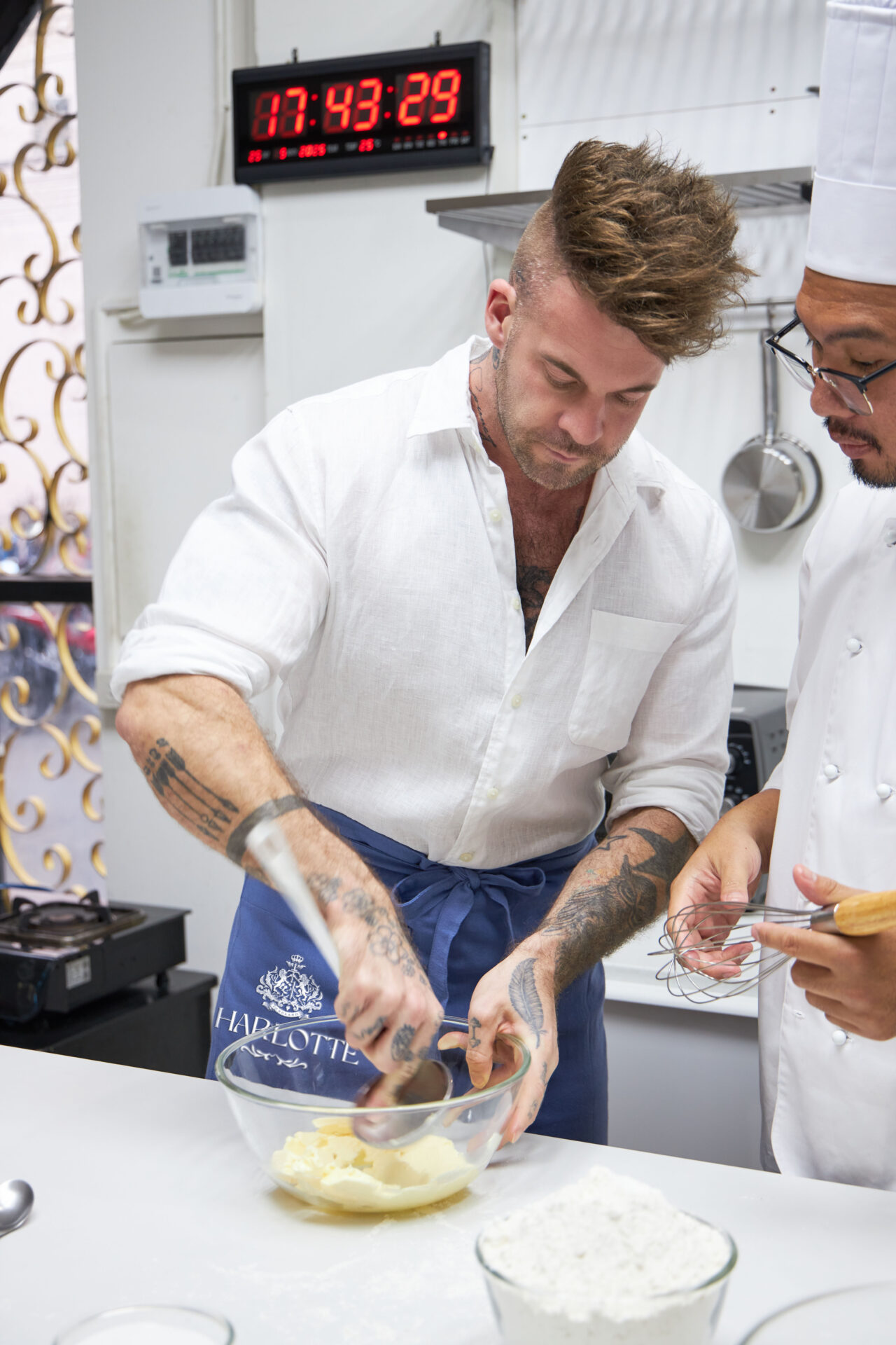 Dan Stoner, founder of Charlotte Bakery Bangkok, and a chef mixing dough and cream during a baking session at the bakery in Bangkok.