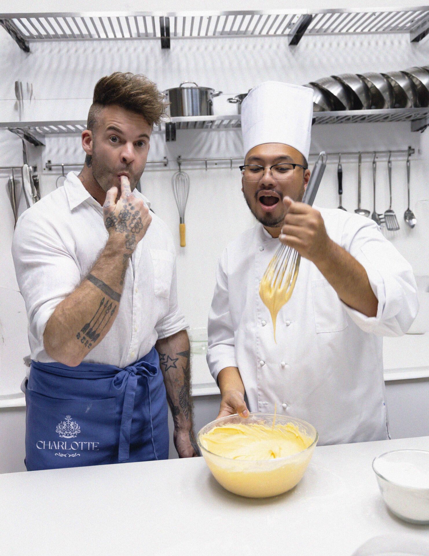 Dan Stoner, founder of Charlotte Bakery Bangkok, and a chef tasting cream while baking at the bakery in Bangkok