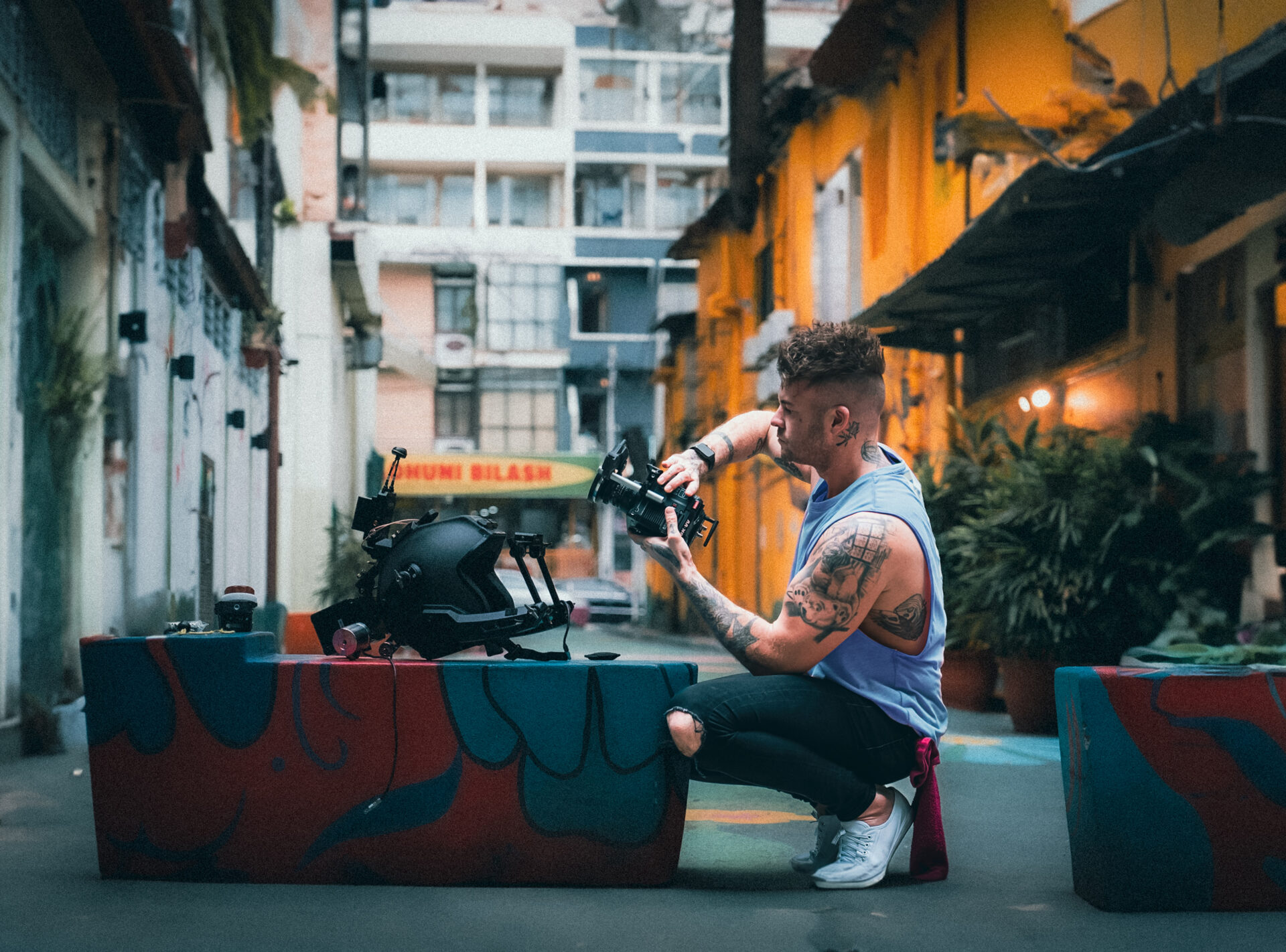 Dan Stoner, founder of Charlotte Bakery Bangkok, setting up camera equipment during a creative outdoor shoot in Malaysia. 