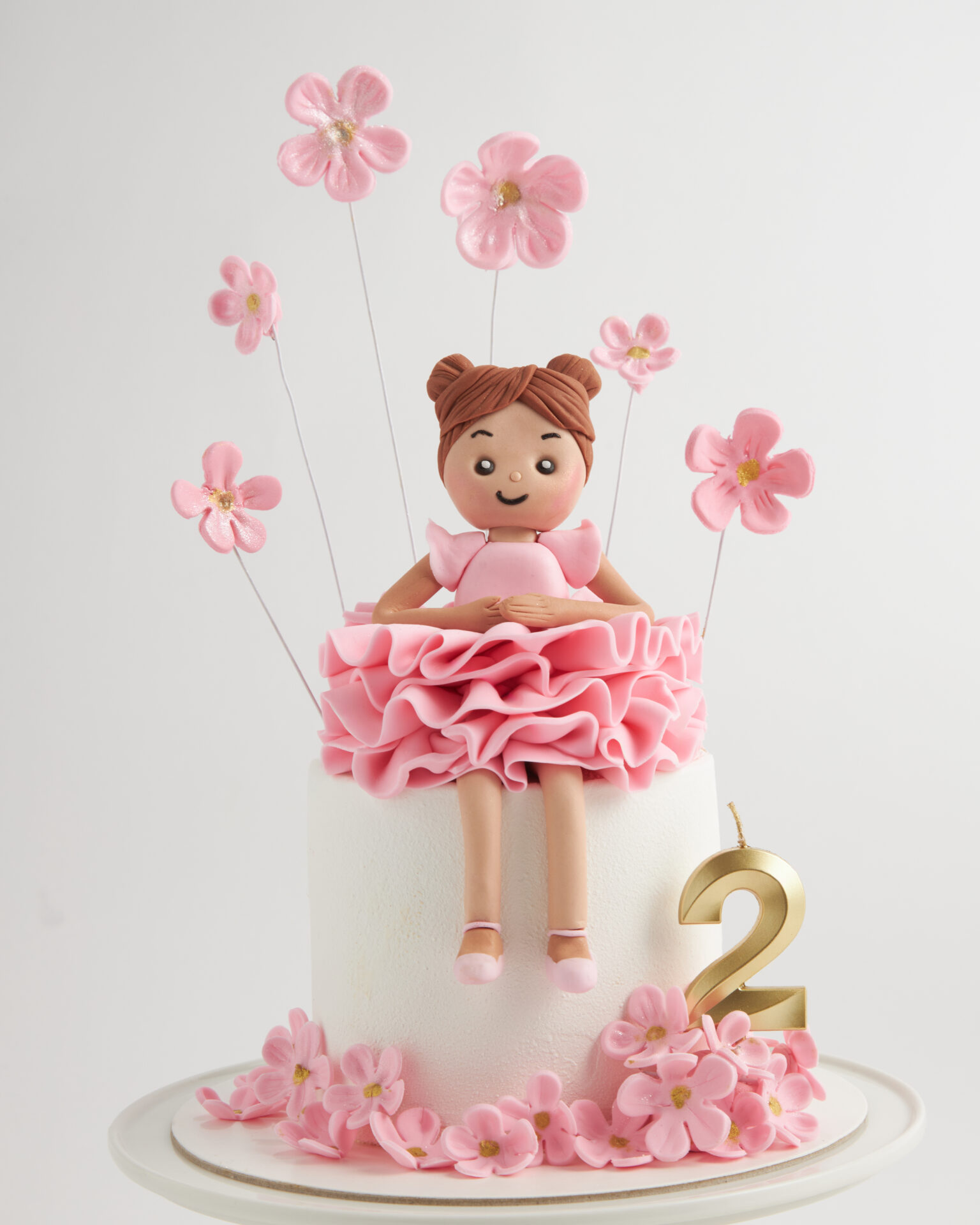 Pink birthday cake with girl figurine topper and flower decorations, Charlotte Bakery Bangkok