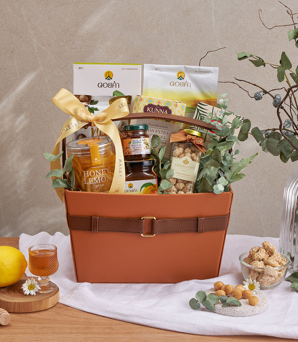 Full view of honey, nuts & dried fruit basket with assorted snacks and drinks in a woven basket.