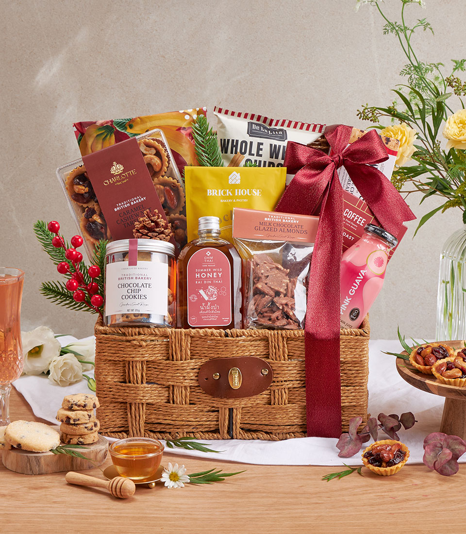 Red gourmet gift basket with assorted snacks and honey.