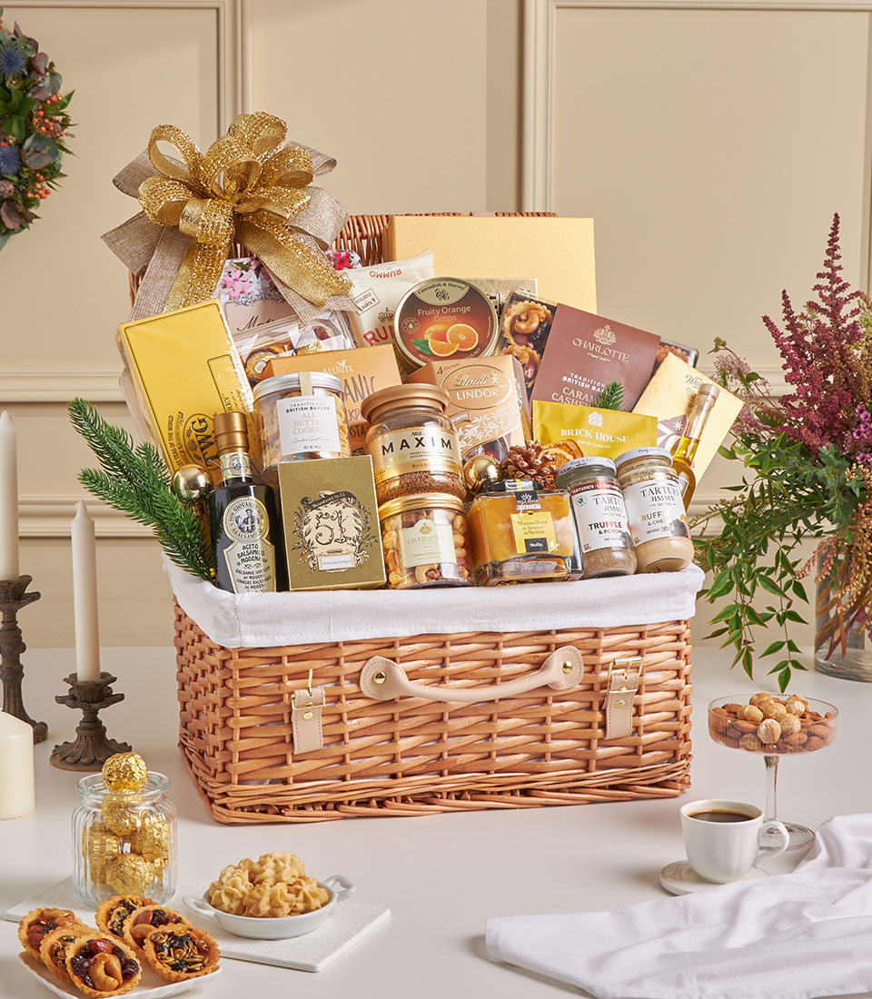 Golden premium gift basket with imported treats in luxury wicker hamper.