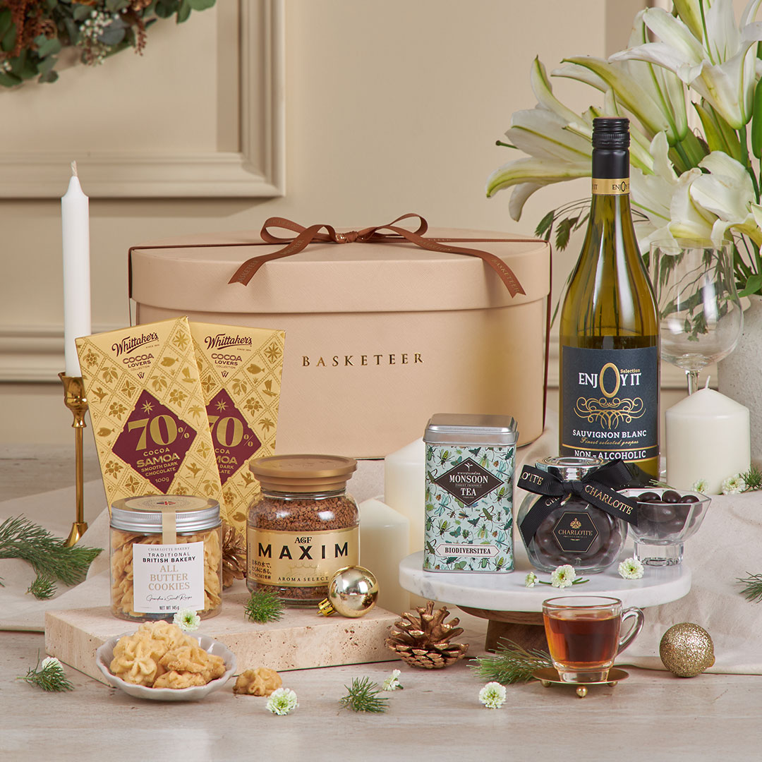 Luxury premium gift basket by Basketeer, featuring fine chocolates, cookies, coffee, tea, and non-alcoholic wine — beautifully arranged in a beige hat box with ribbon, perfect for New Year gifting in Bangkok, Thailand.