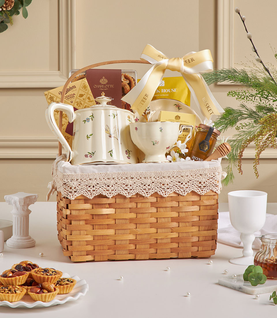 Premium tea set gift basket with ceramic teapot and treats.