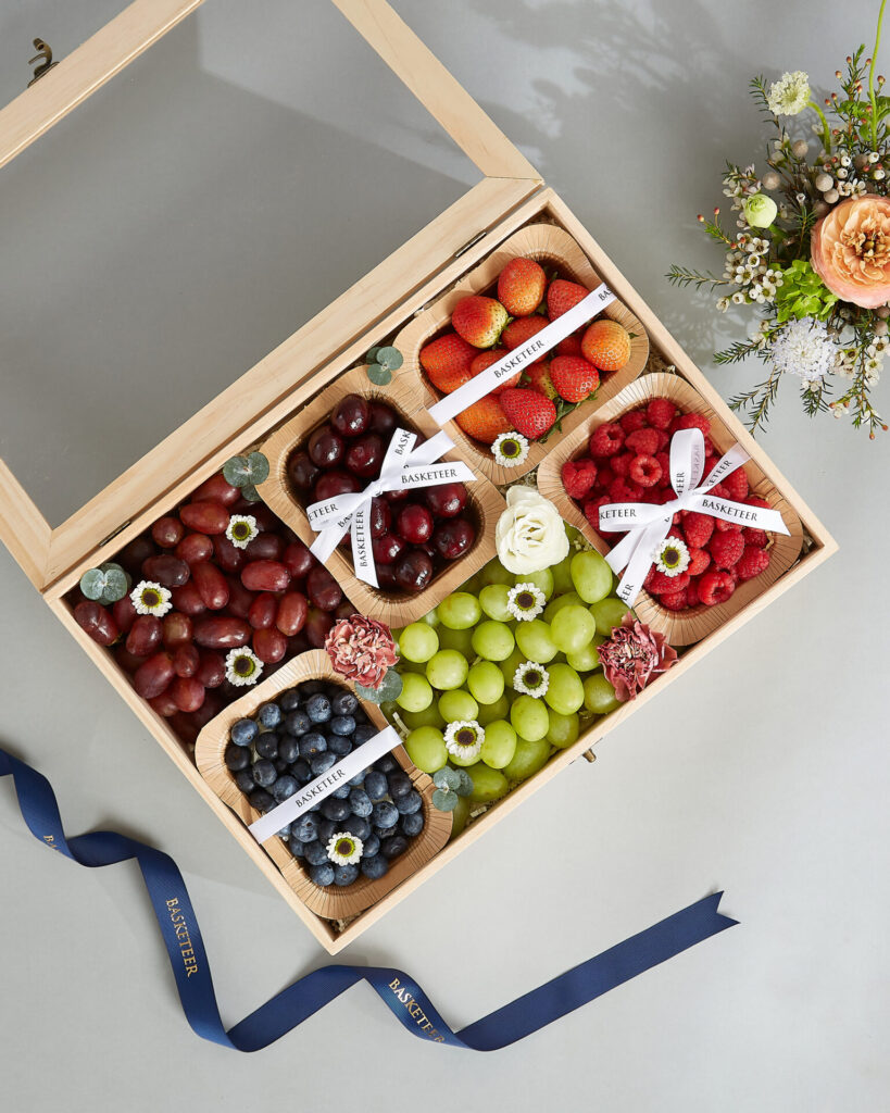 Premium fruit gift box filled with mixed berries, cherries, grapes, and strawberries in a wooden box by Basketeer.