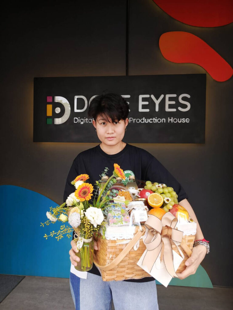Customer receiving a luxury Basketeer fruit and gift basket at Dove Eyes Digital Production House.