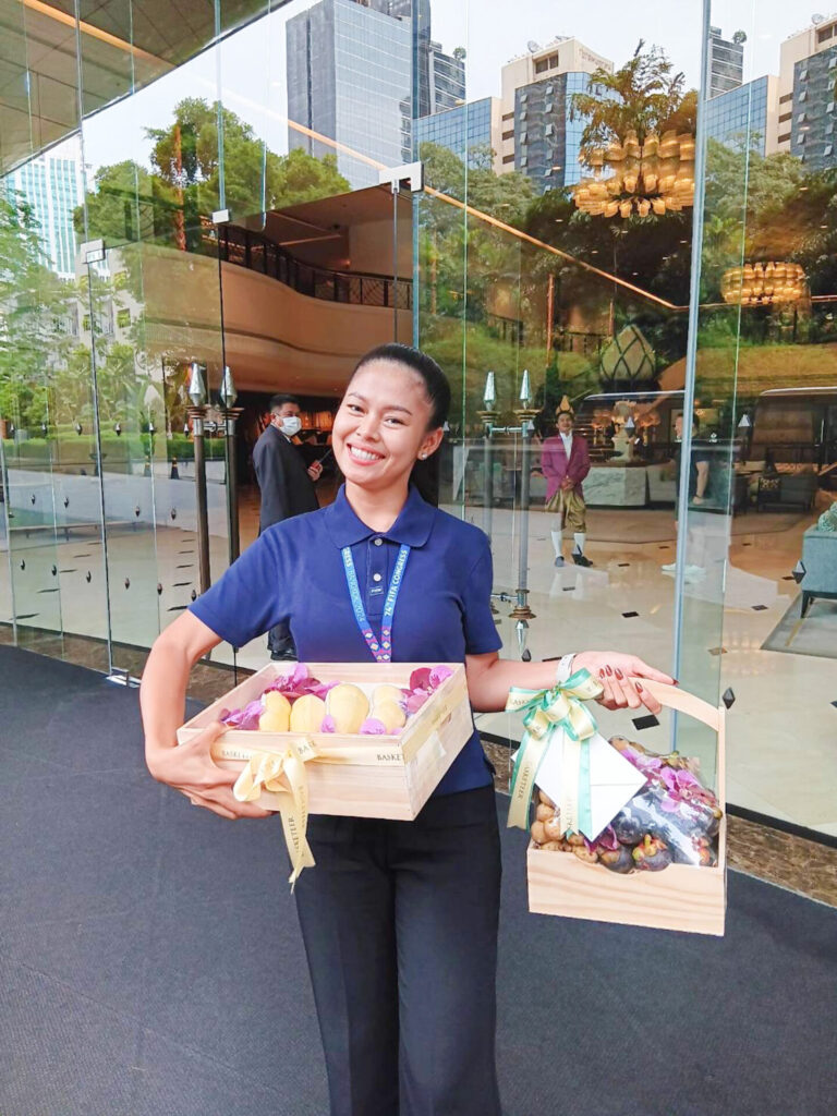 Customer with Basketeer premium wooden fruit gift boxes at hotel entrance