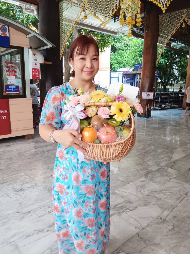Customer holding a pastel-themed Basketeer fruit basket outdoors