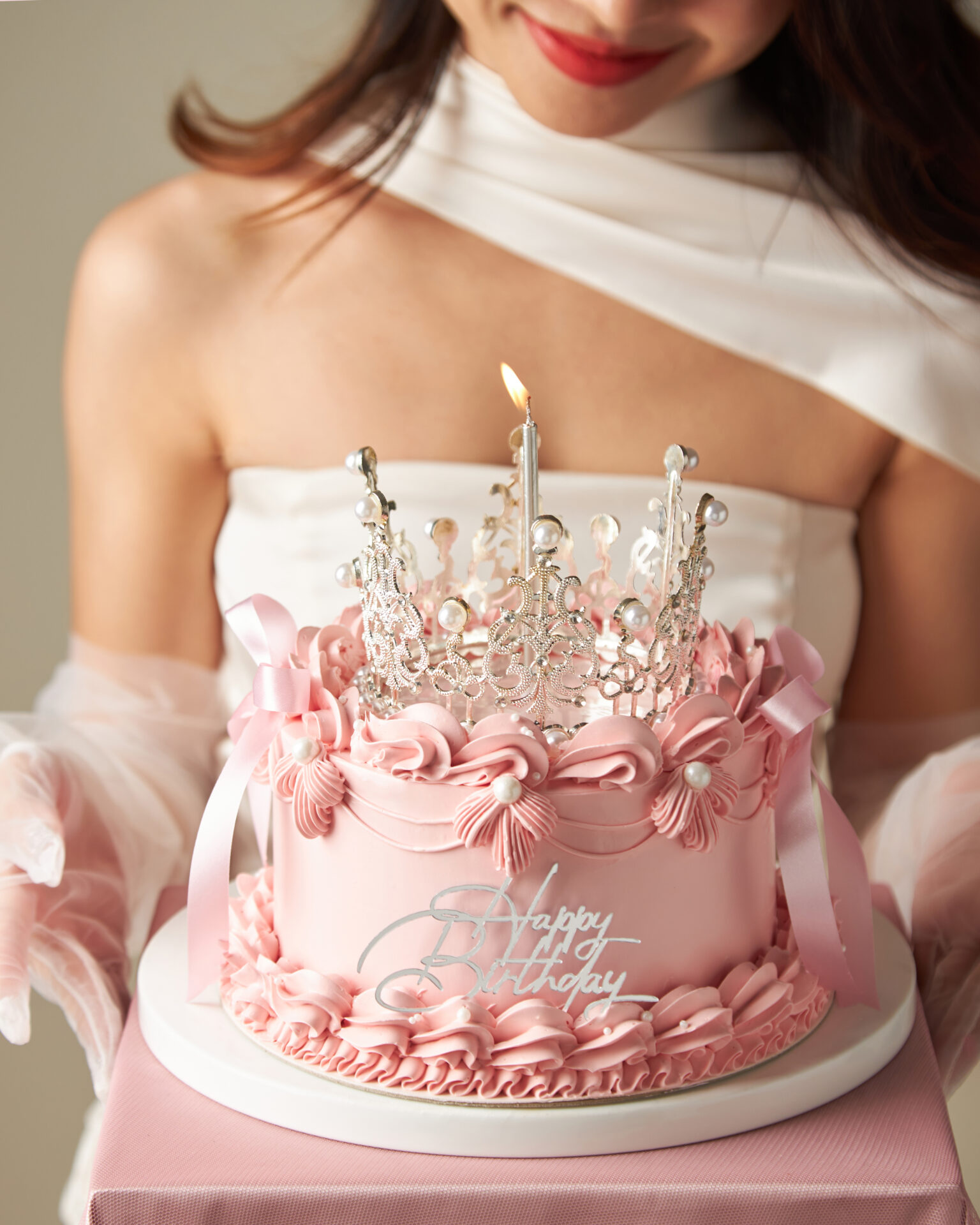Elegant pink Princess Crown Cake with a sparkling crown topper by Charlotte Bakery Bangkok.