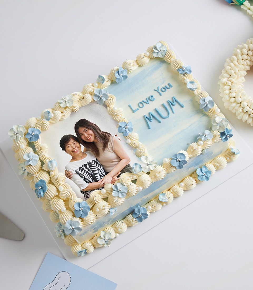 Charlotte Bakery photo cake decorated with blue buttercream flowers and “Love You Mum” lettering.