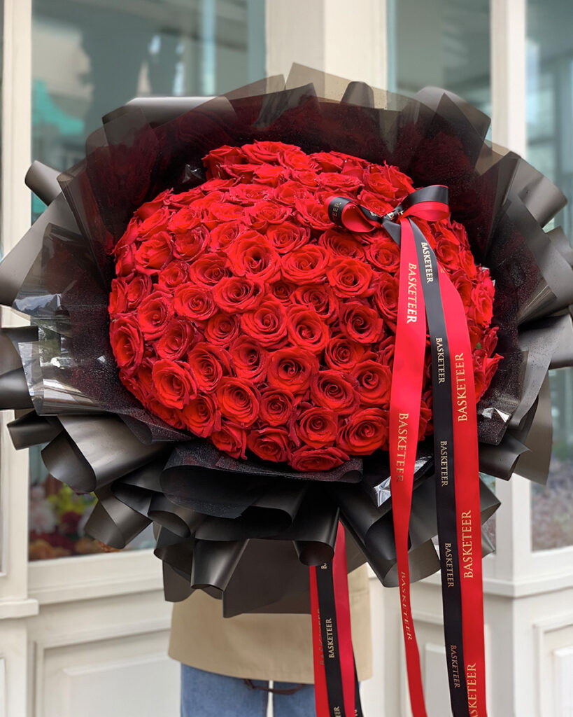 Luxury giant red rose bouquet wrapped in black paper with Basketeer ribbon – premium Explorer Roses from Ecuador.