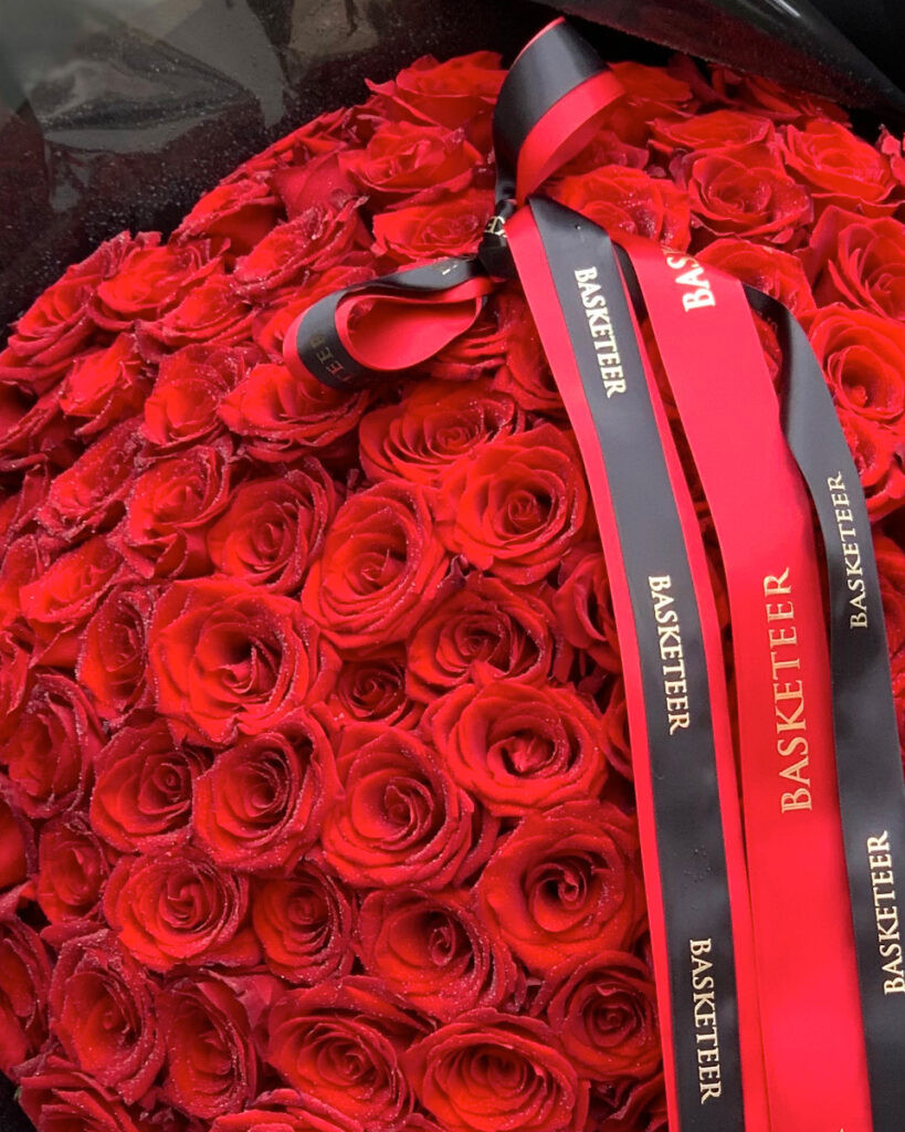 Luxury giant red rose bouquet wrapped in black paper with Basketeer ribbon – premium Explorer Roses from Ecuador.