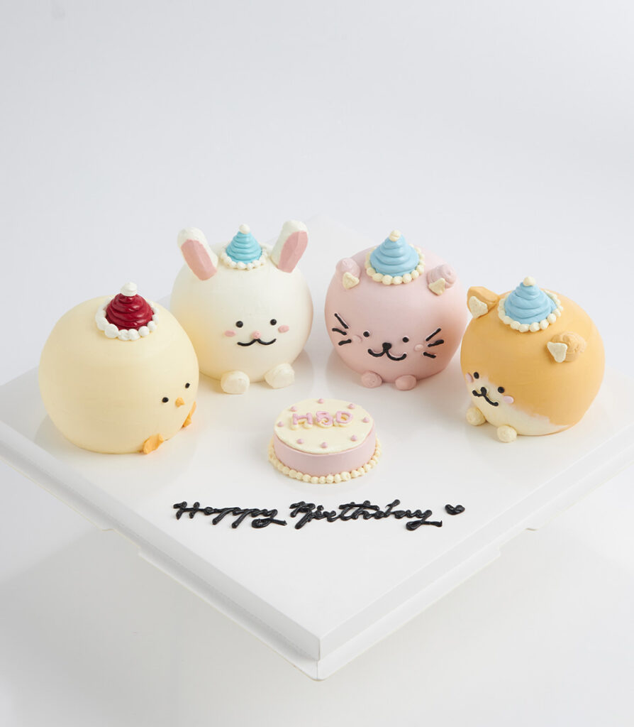Pastel-colored custom birthday cake featuring handcrafted 3D fondant animal faces including a cat, rabbit, dog and chicken.