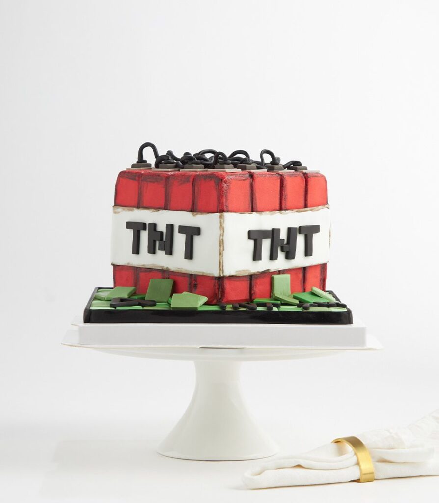 Minecraft-themed square birthday cake designed to look like a red TNT block with 'Happy Birthday' text.