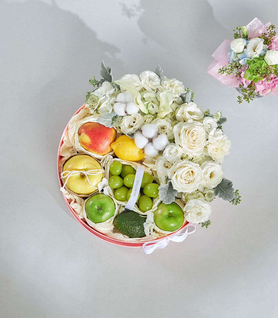 Gourmet white rose fruit basket arrangement.