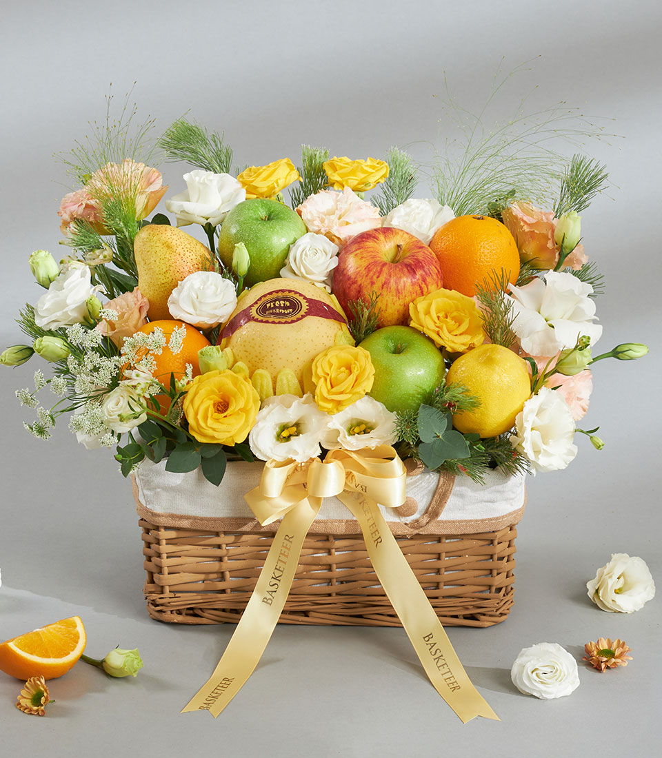 Gourmet fresh fruit basket with yellow roses and mixed fruits.