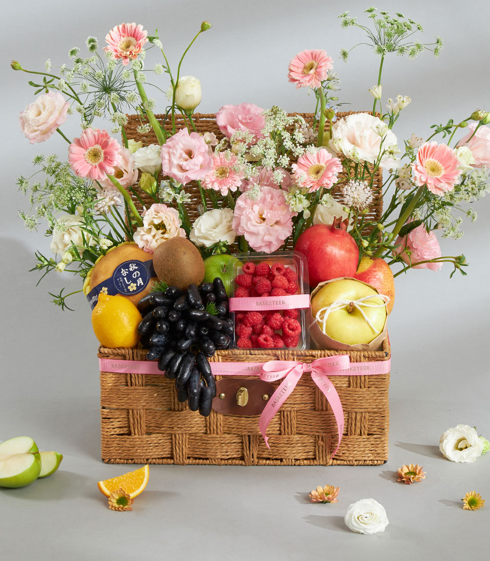 Gourmet fruit and pink flower gift basket.