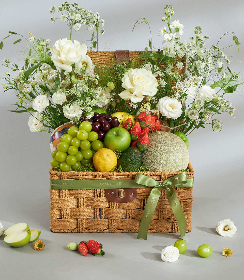 Healthy fresh fruit and flower basket with white roses.