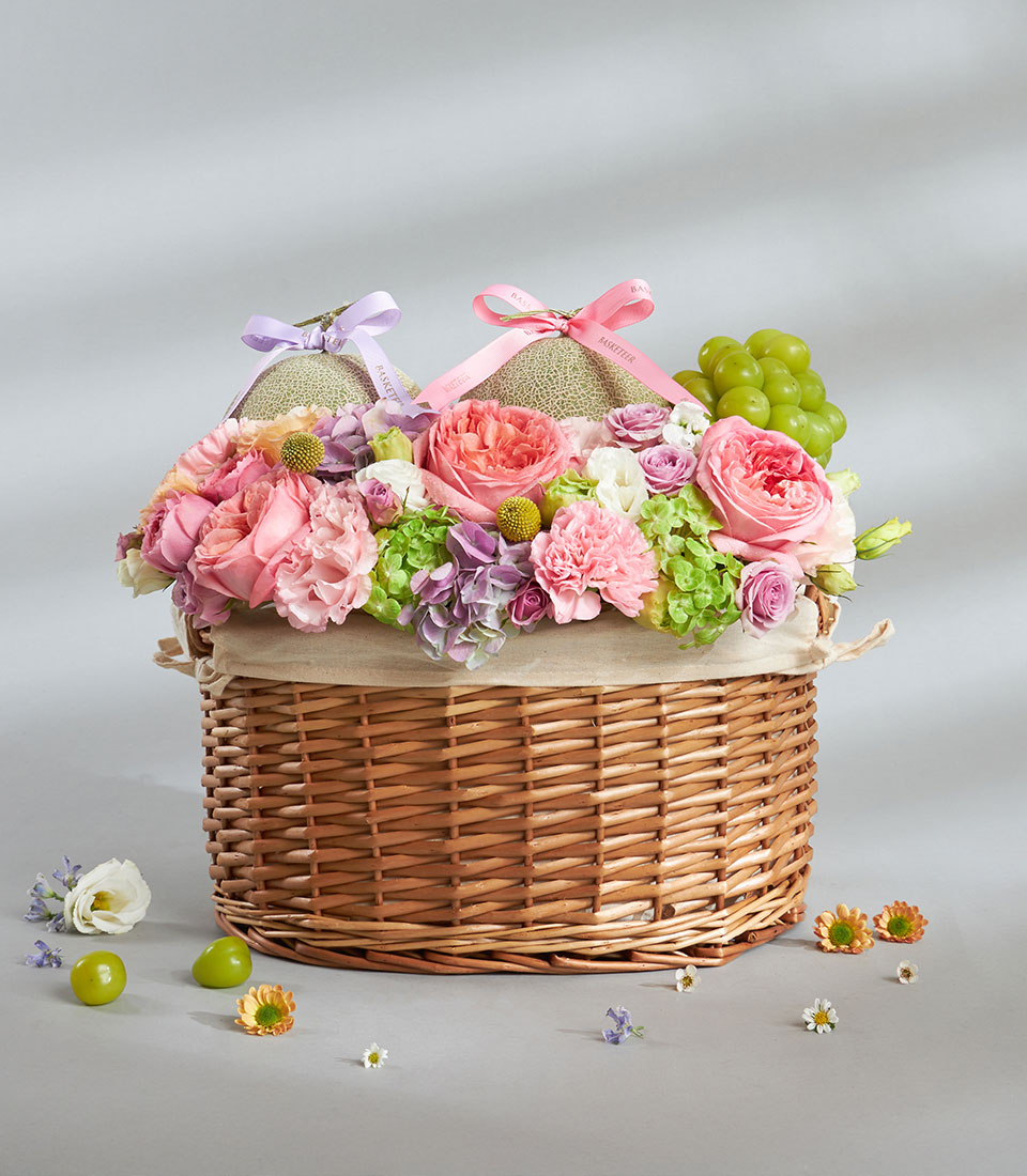 Fresh fruit and pastel flower basket arrangement.