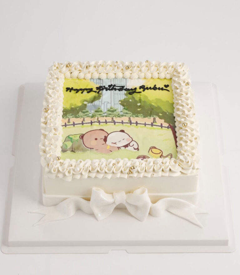 Square birthday cake with cute cartoon illustration and piped cream border by Charlotte Bakery