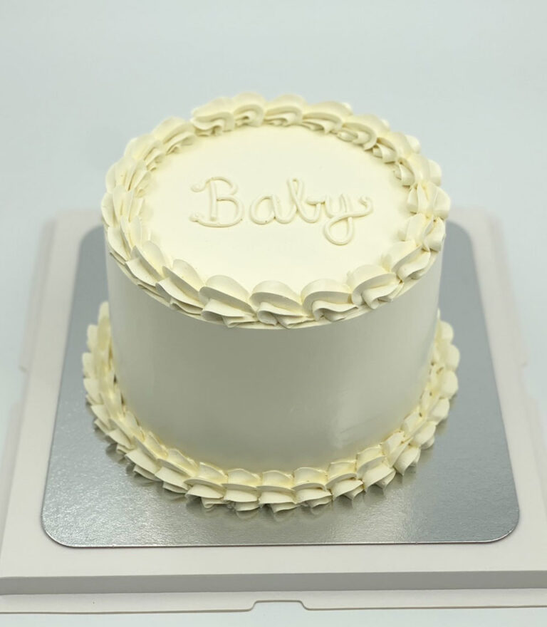 Minimal white buttercream cake with “Baby” lettering by Charlotte Bakery