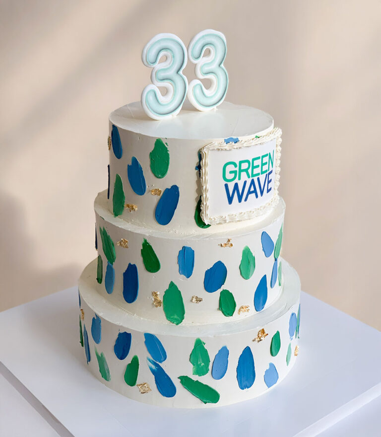 Three-tier white cake with green and blue brushstrokes and number 33 topper by Charlotte Bakery