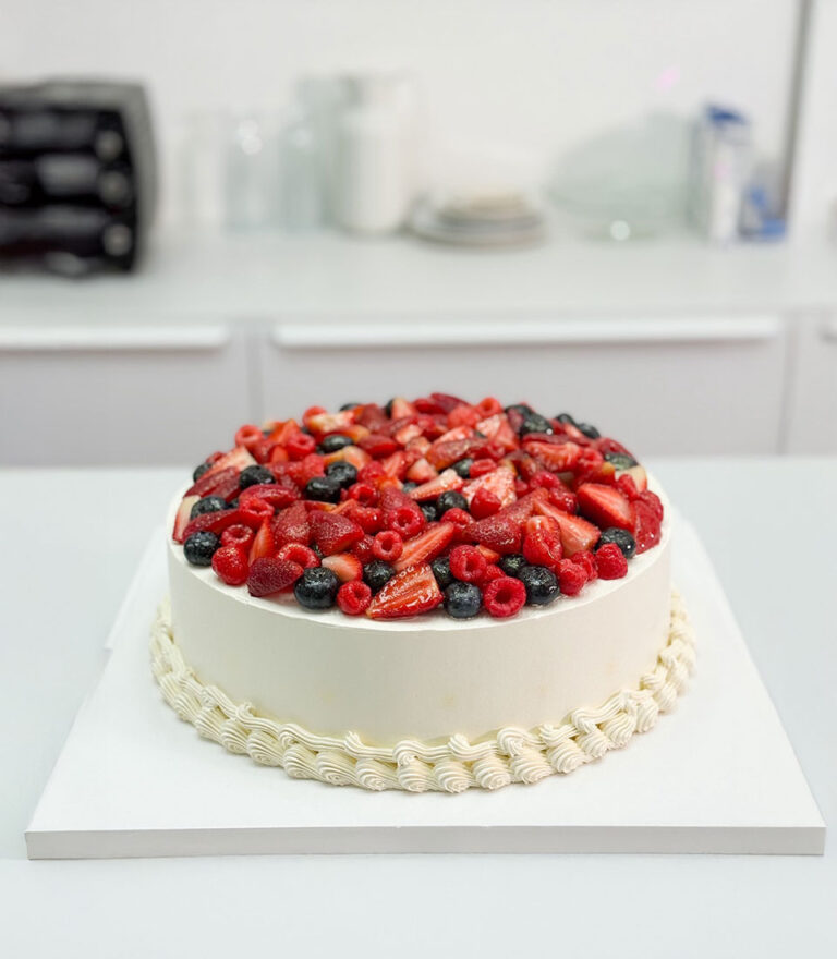 Charlotte Bakery berry-topped Victoria sponge cake with fresh strawberries, raspberries, and blueberries for an anniversary celebration in Bangkok.
