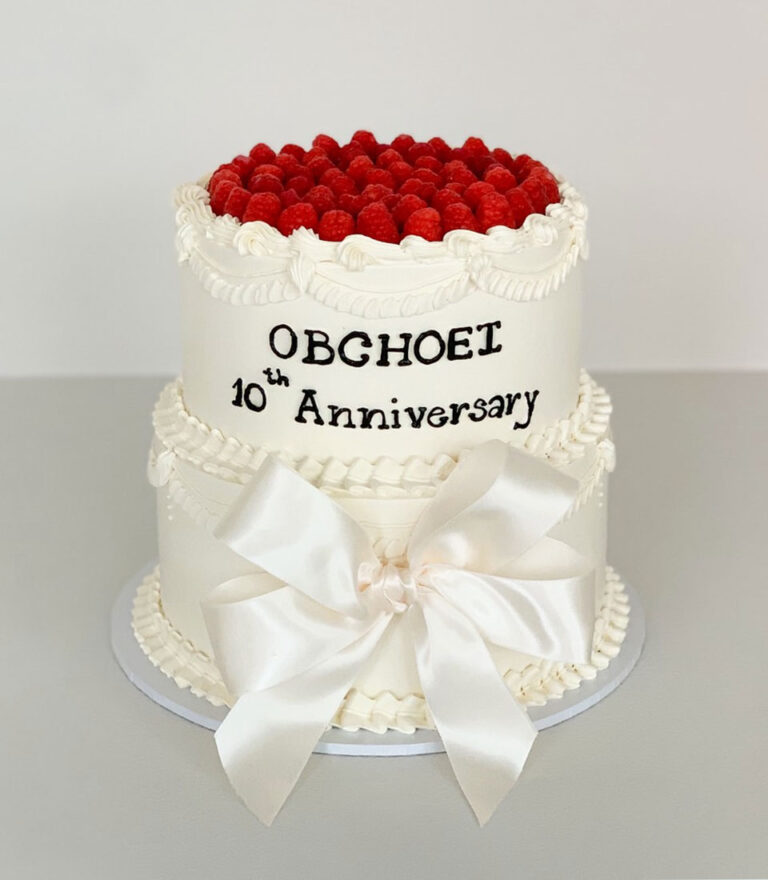 Charlotte Bakery classic anniversary cake topped with fresh raspberries and finished with traditional buttercream piping.
