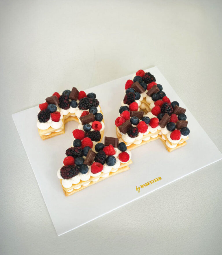Letter cake from Charlotte Bakery topped with fresh cream and balanced garnish.