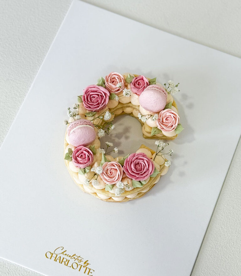 Letter cake by Charlotte Bakery layered with fresh cream and minimal garnish.