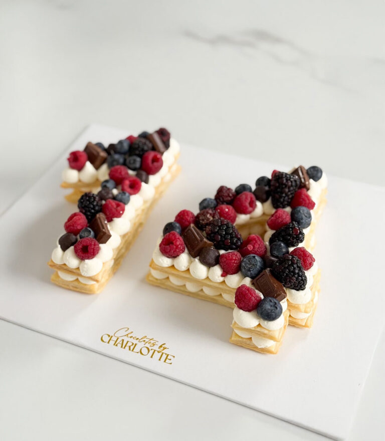 Minimalist letter cake by Charlotte Bakery highlighting sponge texture and simple decoration.