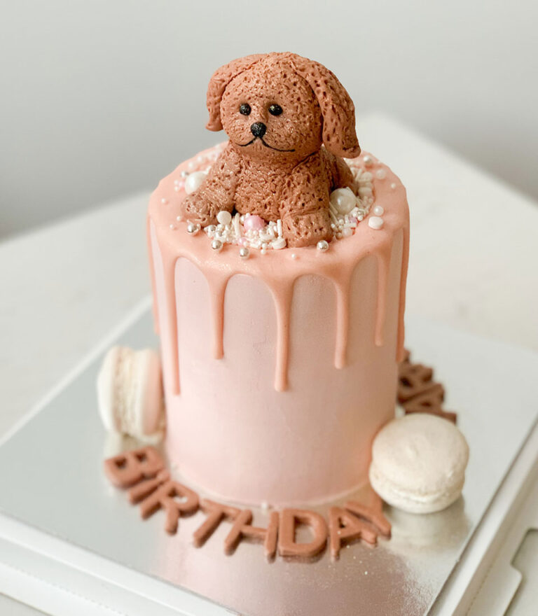 Fondant birthday cake topped with a handcrafted puppy figure by Charlotte Bakery in Bangkok.