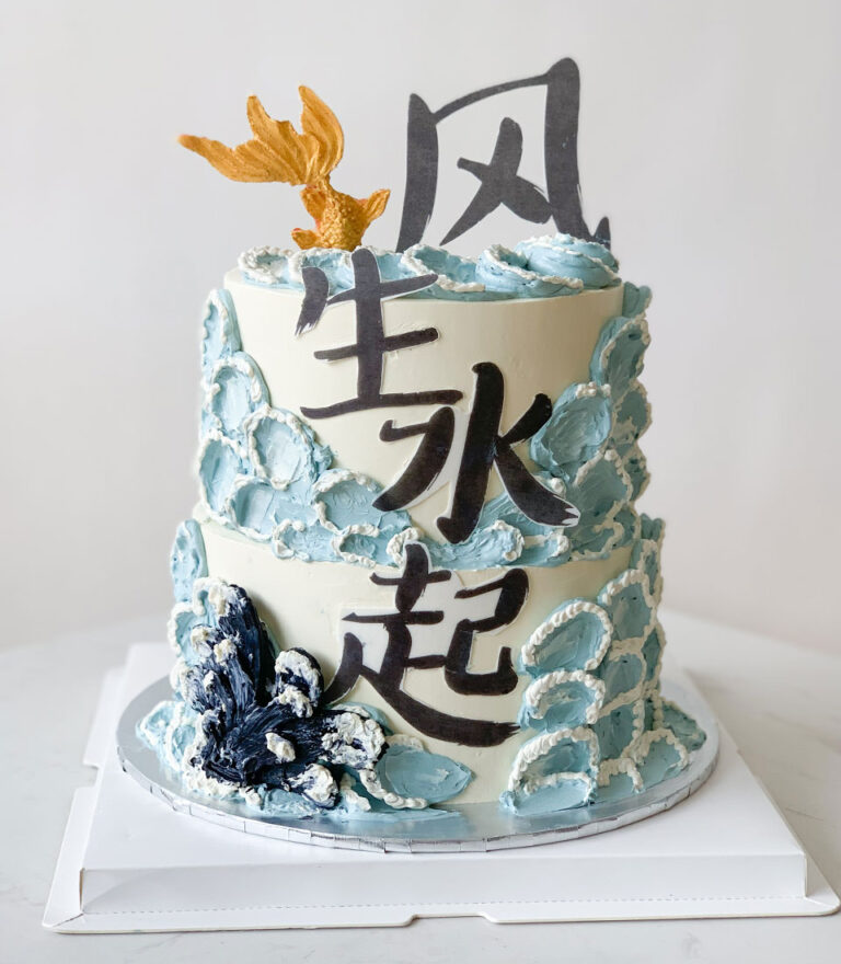 Artistic birthday cake with wave-textured buttercream and calligraphy details by Charlotte Bakery in Bangkok.