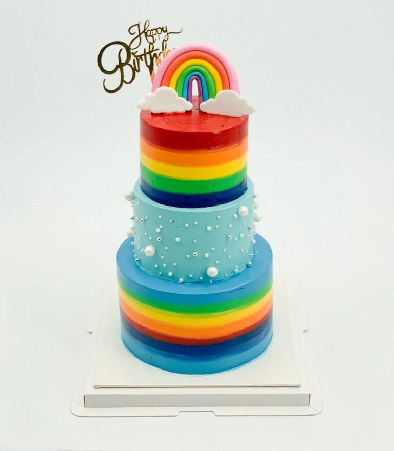 Rainbow layered birthday cake with playful topper by Charlotte Bakery in Bangkok