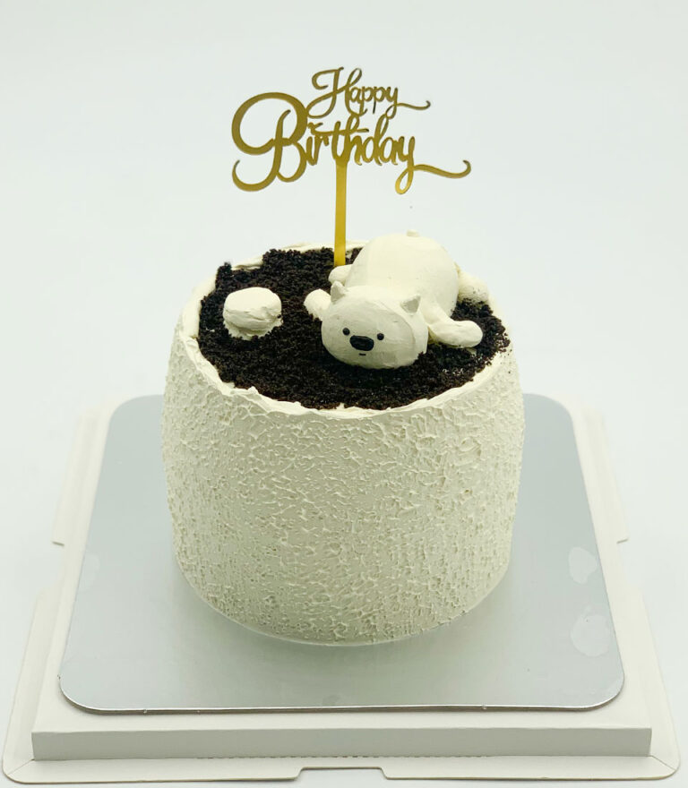 Minimal buttercream birthday cake topped with a sleeping polar bear figure by Charlotte Bakery in Bangkok