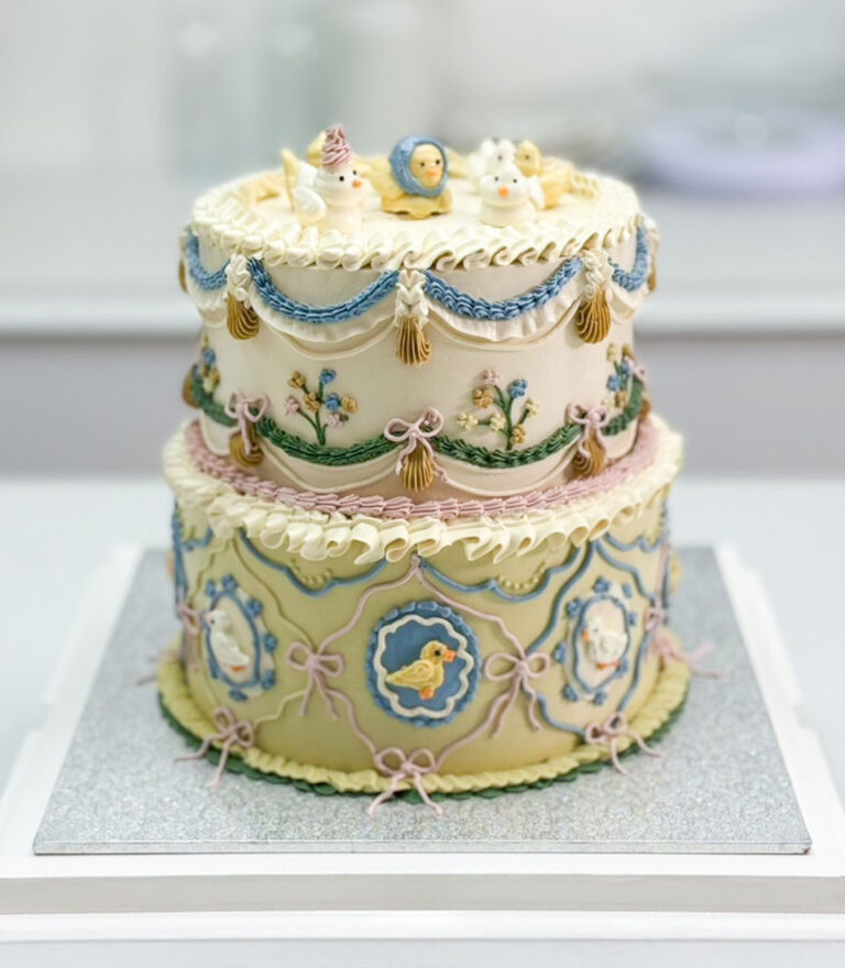 Vintage-style tiered birthday cake with pastel piping and delicate animal details by Charlotte Bakery in Bangkok